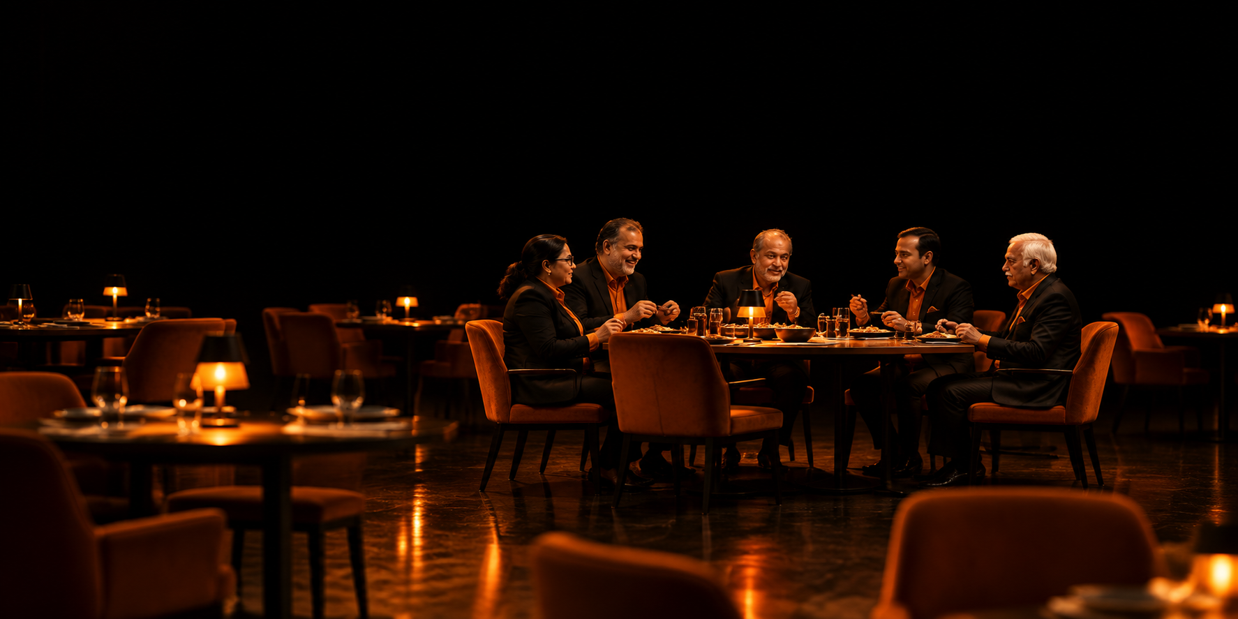Elegant group dining scene in a luxury restaurant with guests enjoying a meal at a table under warm orange lighting and a dark premium atmosphere